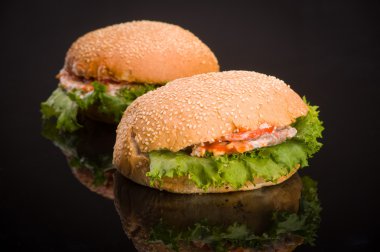 Masanın üzerinde yansıması ile iki lezzetli hamburger.