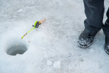 Buz balıkçılığı, olta deliğe yakın duruyor..