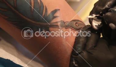 Dövme sanatçısı ışık mavi mürekkep ile bir dövme gölgelendirme