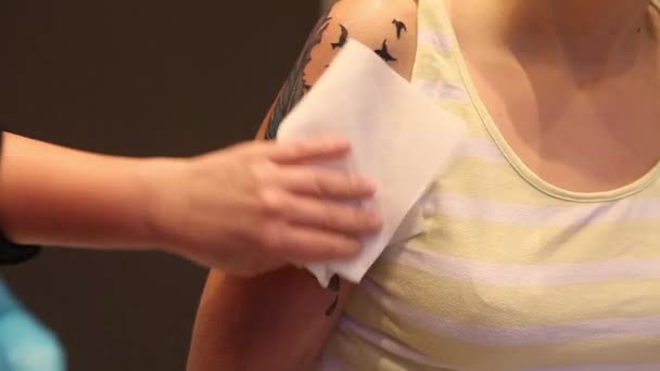 Tatuaggio artista pulire il tatuaggio con un disinfettante — Video Stock