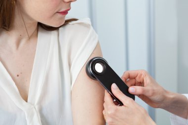 Dermatolog doğum lekeleri ve mol Bayan hasta üzerinde incelenmesi