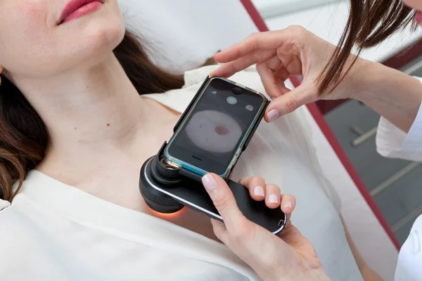 Dermatólogo examinando marcas de nacimiento y lunares en una paciente femenina —  Fotos de Stock