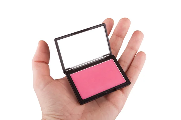 Mão feminina segurando um blush rosa, isolado em branco — Fotografia de Stock