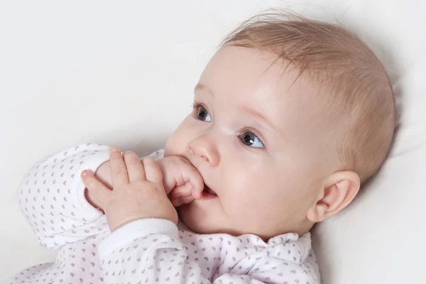 Niedliches kleines Mädchen, das auf ihrer Hand kaut — Stockfoto