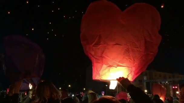 Люди выпускают бумажные фонари ночью — стоковое видео