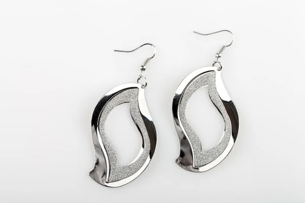 Pair of silver earrings on white background — Stock Photo, Image