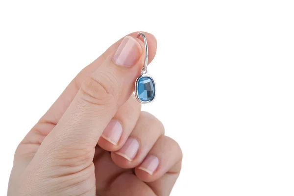 Female hand holding a sapphire earring — Stock Photo, Image
