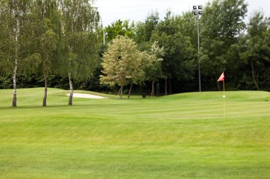 bir golf sahası üstünde kırmızı bayrak