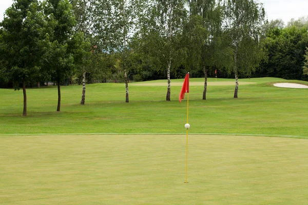 Bandera roja en un campo de golf —  Fotos de Stock