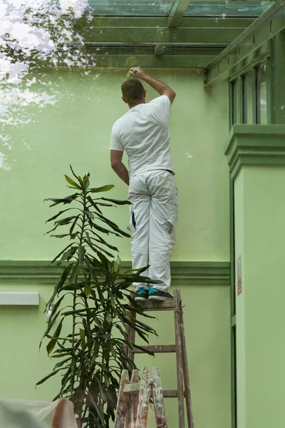 Un homme peignant des murs en vert — Photo