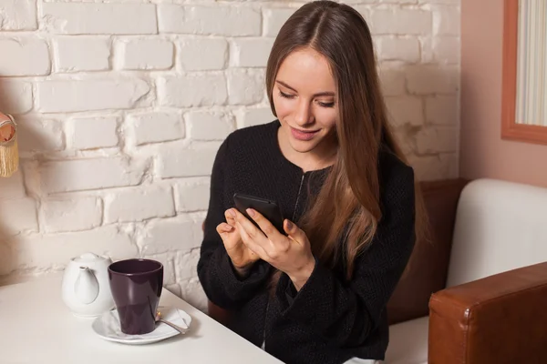 Vrouw met thee en smartphone — Stockfoto