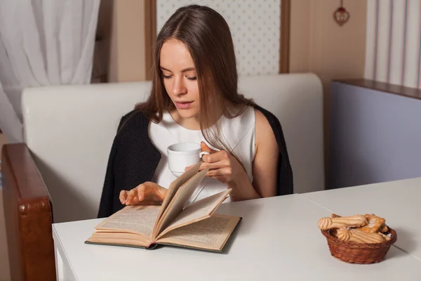 Kvinna med bok och te — Stockfoto