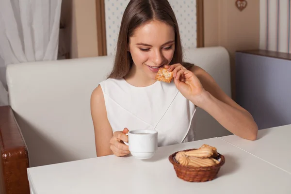 Vrouw met koekjes en thee — Stockfoto