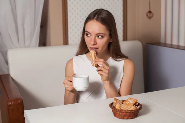 Vrouw met koekjes en thee — Stockfoto