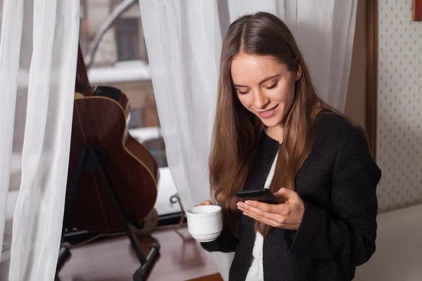 Vrouw met koffie in de buurt van venster — Stockfoto