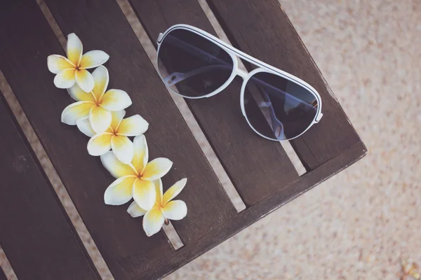 Tropische bloemen en zonnebril op de Bank — Stockfoto