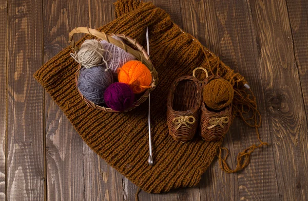 Sapatos de malha e peça e uma agulha e uma cesta — Fotografia de Stock
