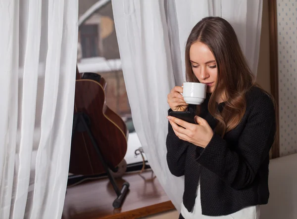 Kvinna med kaffe nära fönster — Stockfoto