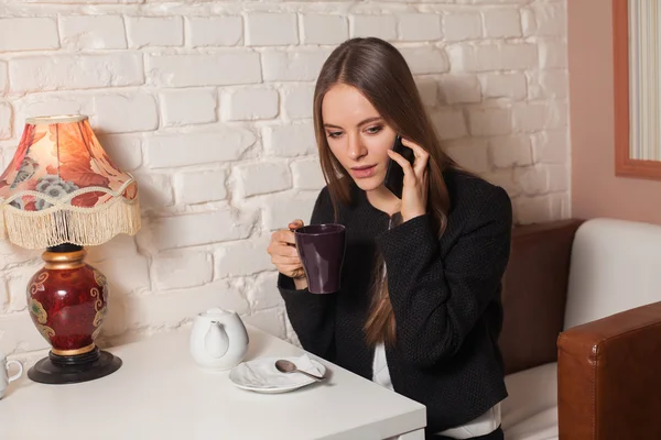 Kobieta z herbaty i smartphone — Zdjęcie stockowe