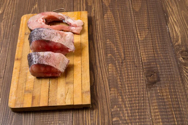 Três pedaços de peixe estão na prancha — Fotografia de Stock