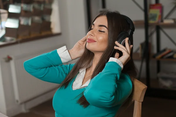 Mujer con auriculares en silla —  Fotos de Stock