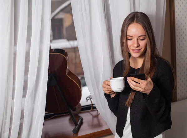 Kvinna med kaffe nära fönster — Stockfoto