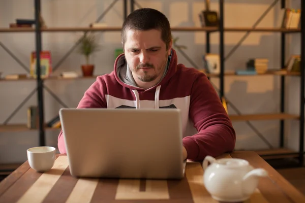 Mann mit Kapuze und Laptop — Stockfoto