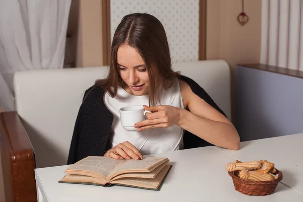 Mulher com livro e chá — Fotografia de Stock