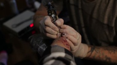 Dövme sanatçısı salonda çalışıyor