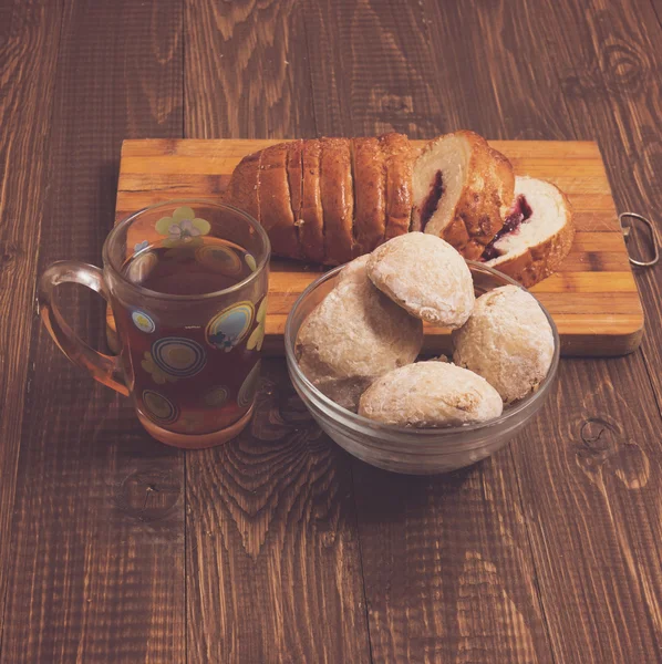 Cutted loaf with tea and buns — Stock Photo, Image
