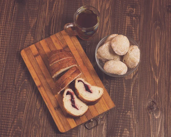 Cutted loaf with buns and tea — Stock Photo, Image