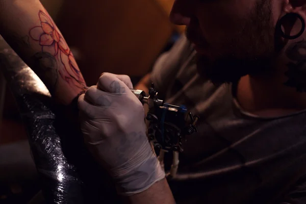 Tattoo artist works in salon — Stock Photo, Image