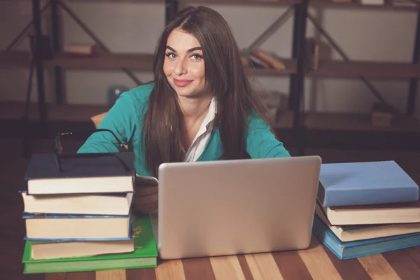 Tavolo in legno con tanti libri e donna — Foto Stock