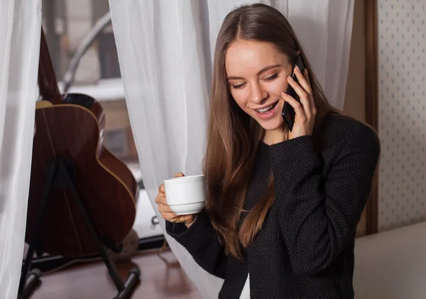 Kvinna med kaffe nära fönster — Stockfoto