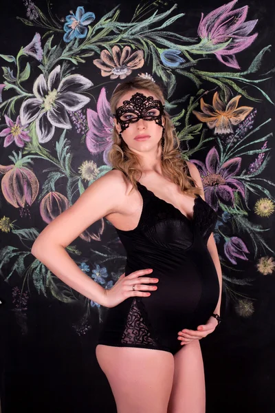 Gravid kvinna i svart underkläder och mask — Stockfoto