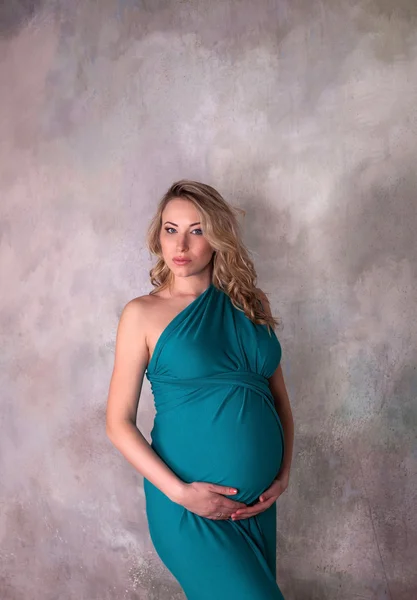 Těhotná žena v modrých šatech — Stock fotografie