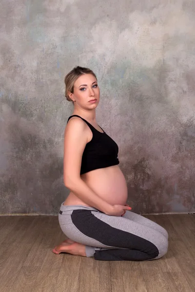 Zwangere vrouw in sportkleding — Stockfoto