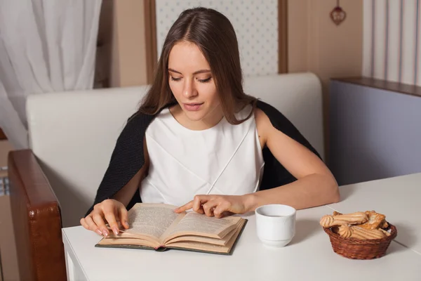 Frau mit Buch und Tee — Stockfoto