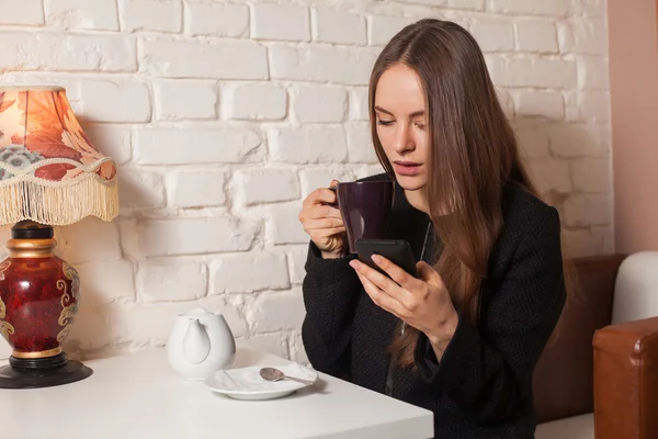 Woman with tea and smartphone — Stock Photo, Image