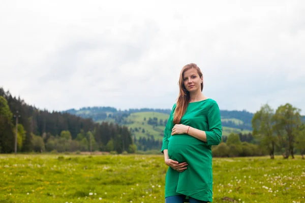 Pregnant woman in a green tunic — Stock Photo, Image