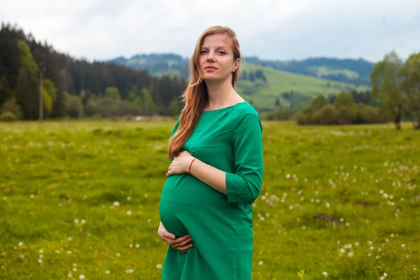 Pregnant woman in a green tunic — Stock Photo, Image