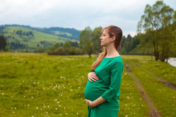 Pregnant woman in a green tunic — Stock Photo, Image