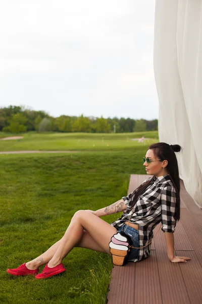 La femme est assise sur un plancher de bois — Photo