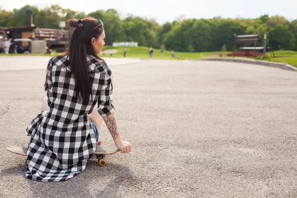 A mulher senta-se no skate — Fotografia de Stock