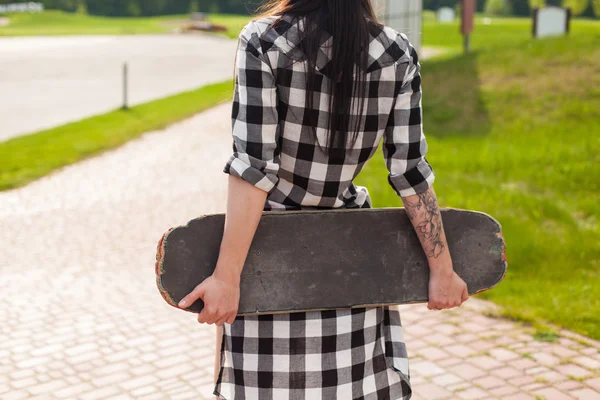 A mulher segura um skate — Fotografia de Stock