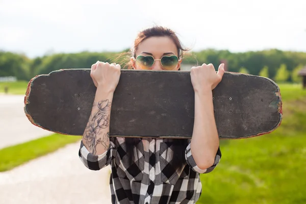 De vrouw houdt een skate — Stockfoto