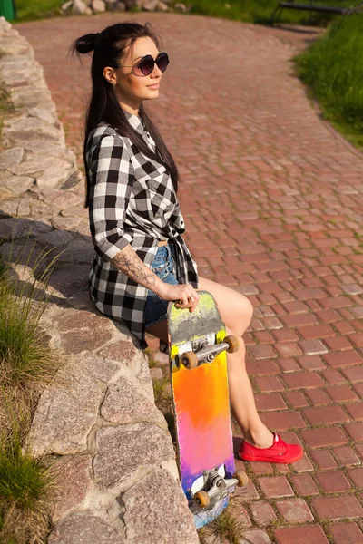 De vrouw staat met een skate — Stockfoto