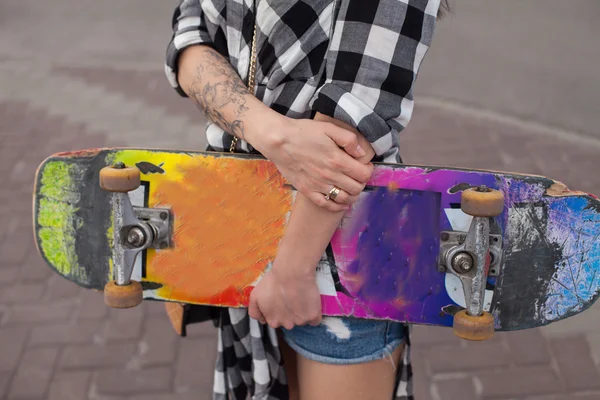 De vrouw houdt een skate — Stockfoto