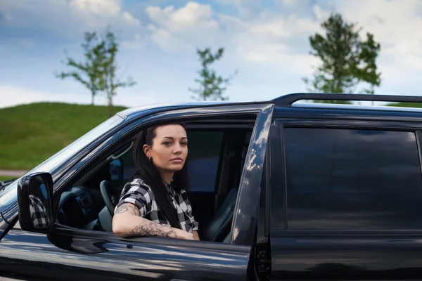 La femme est près d'une voiture. — Photo