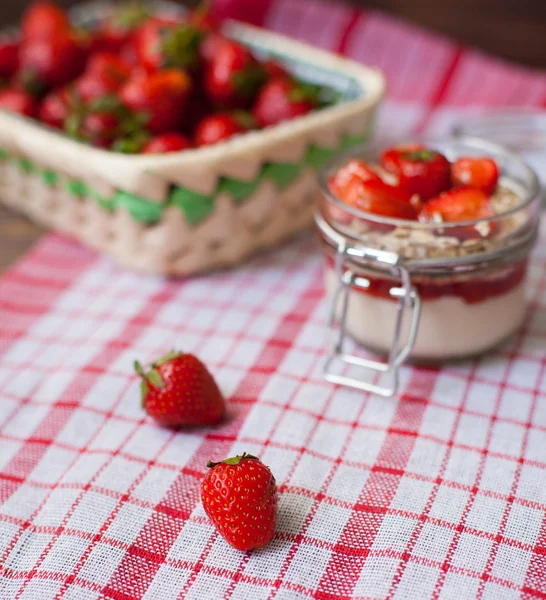 Fresh strawberries on the tablecloth and in the basket — Stock Photo, Image